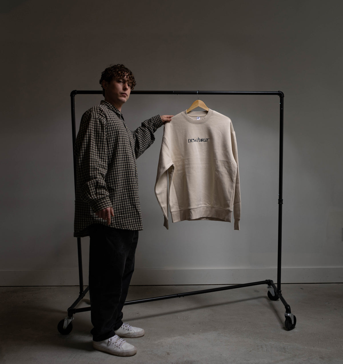 Founder Connor Closs standing by clothing rack